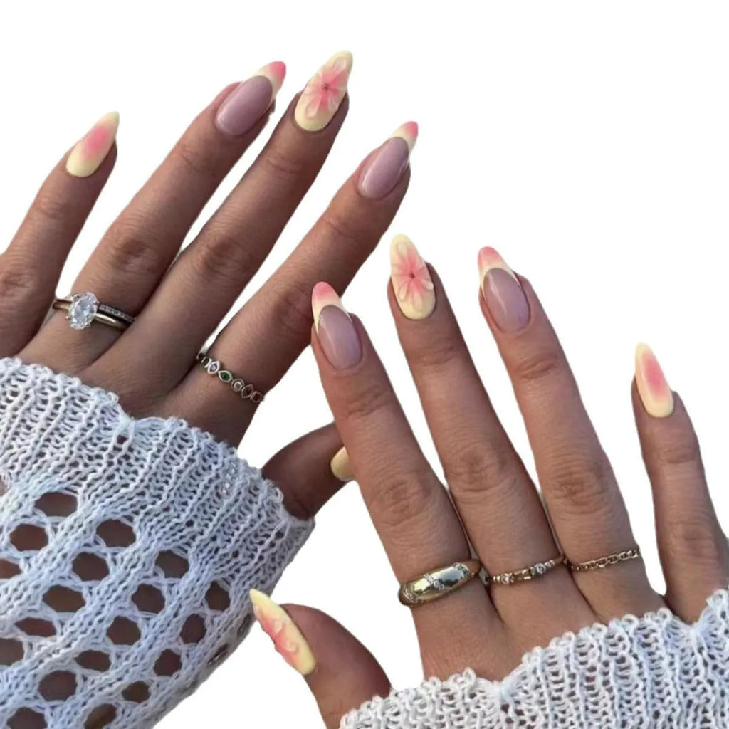 Fake nails set with white plastic armour pieces featuring raised pink and green cartoon flower designs.