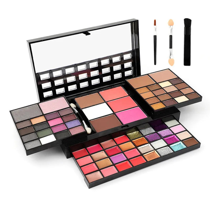 Open 74-colour makeup palette showing four layers of eyeshadow, lip gloss, blush, and contour powders with included brushes.