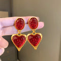 A pair of alloy pleated oval heart-shaped stud earrings with silver posts on a white background.