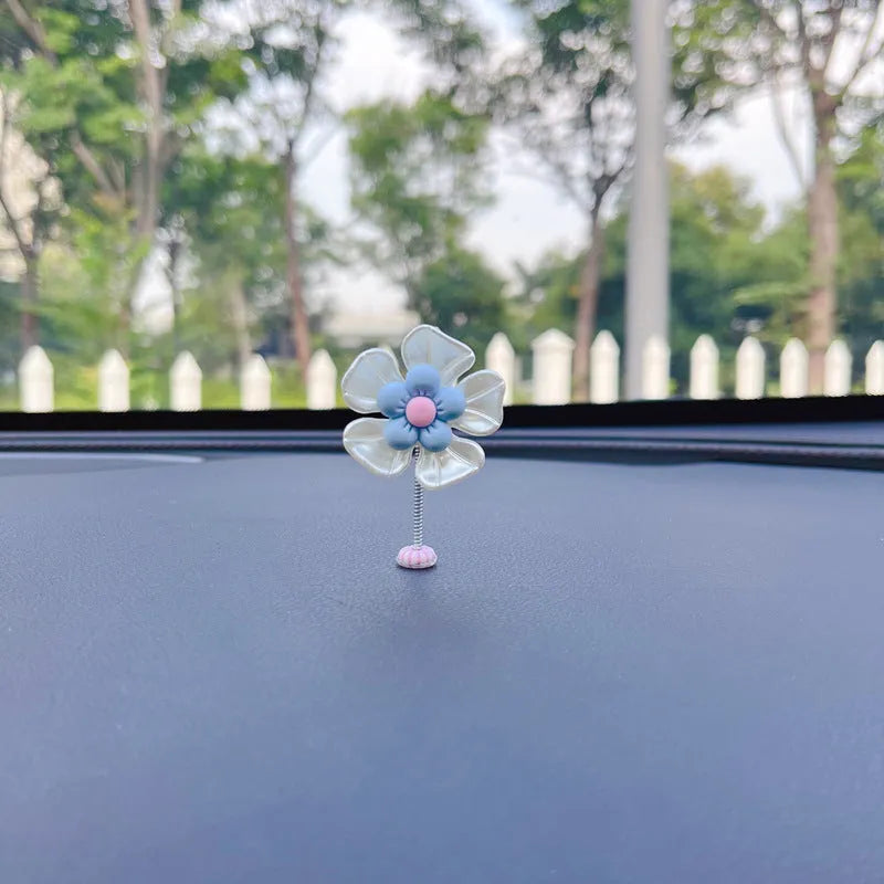 Blue plastic swing-shaped car decoration with a smiling face, hanging from a loop.