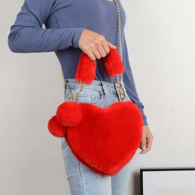 Soft plush heart-shaped women's handbag in a medium size with a removable shoulder strap.