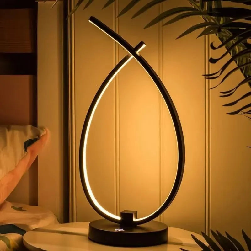 Modern black water drop shaped USB table lamp with touch control on wooden bedside table