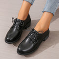 Black women's low-top work shoes with a chunky rubber heel and pointed toe.