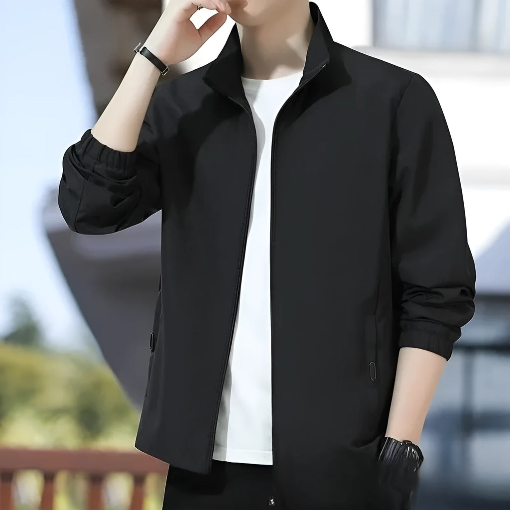 Man wearing a loose-fit black lapel jacket, Korean-style casual autumn coat with zipper pockets.
