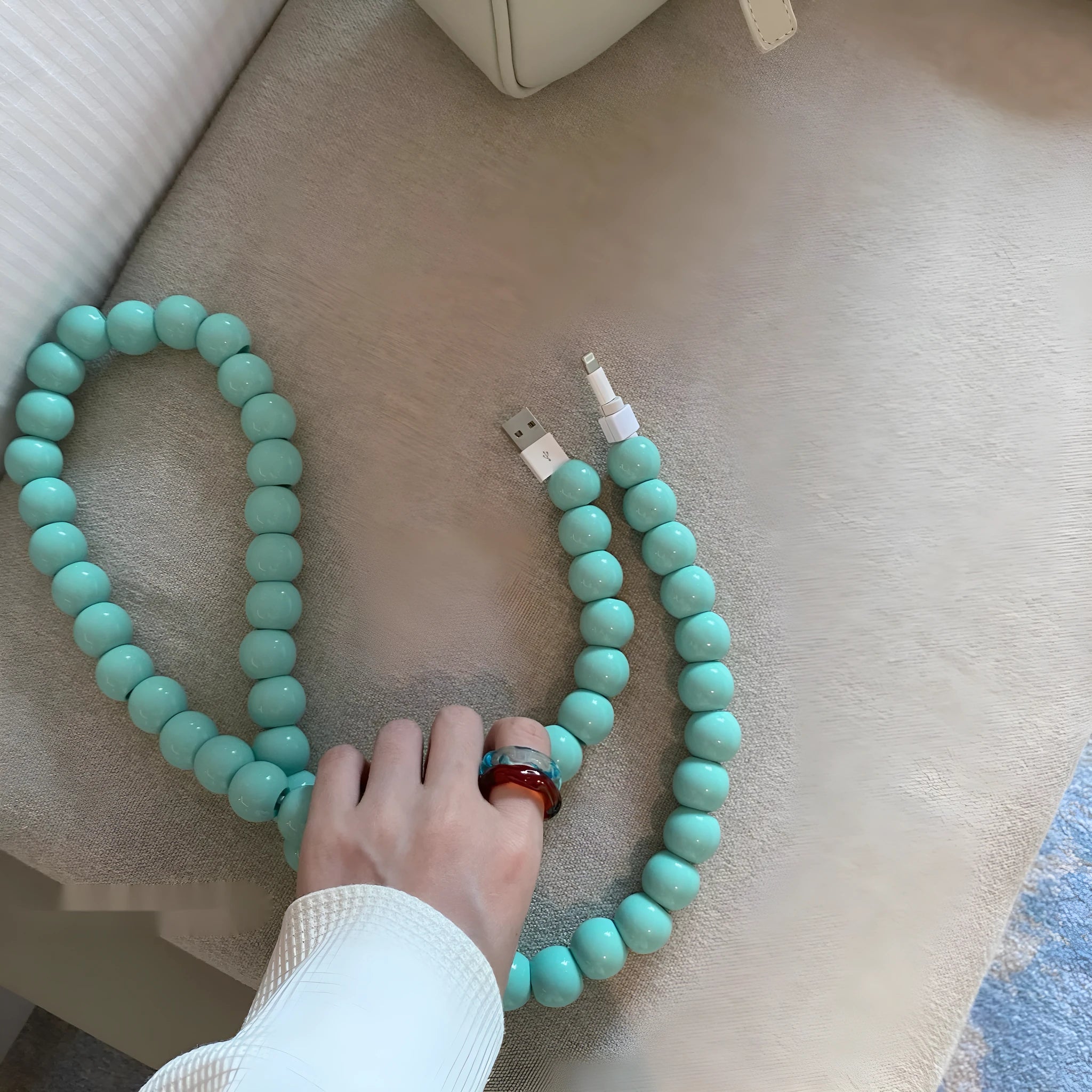 Mint green USB data cable with straight head connector on a white background