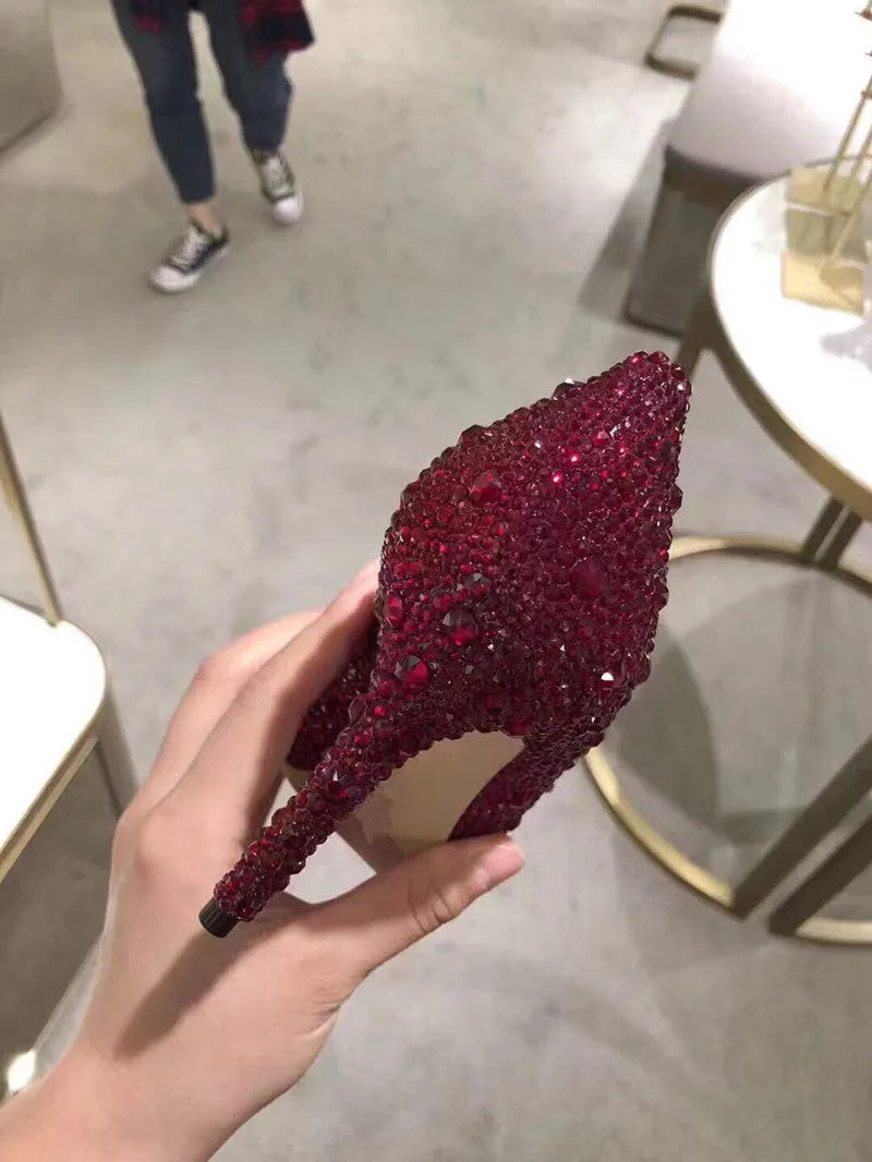 Women's gold pointed toe stiletto high heels with sequin cloth and rhinestone decoration.