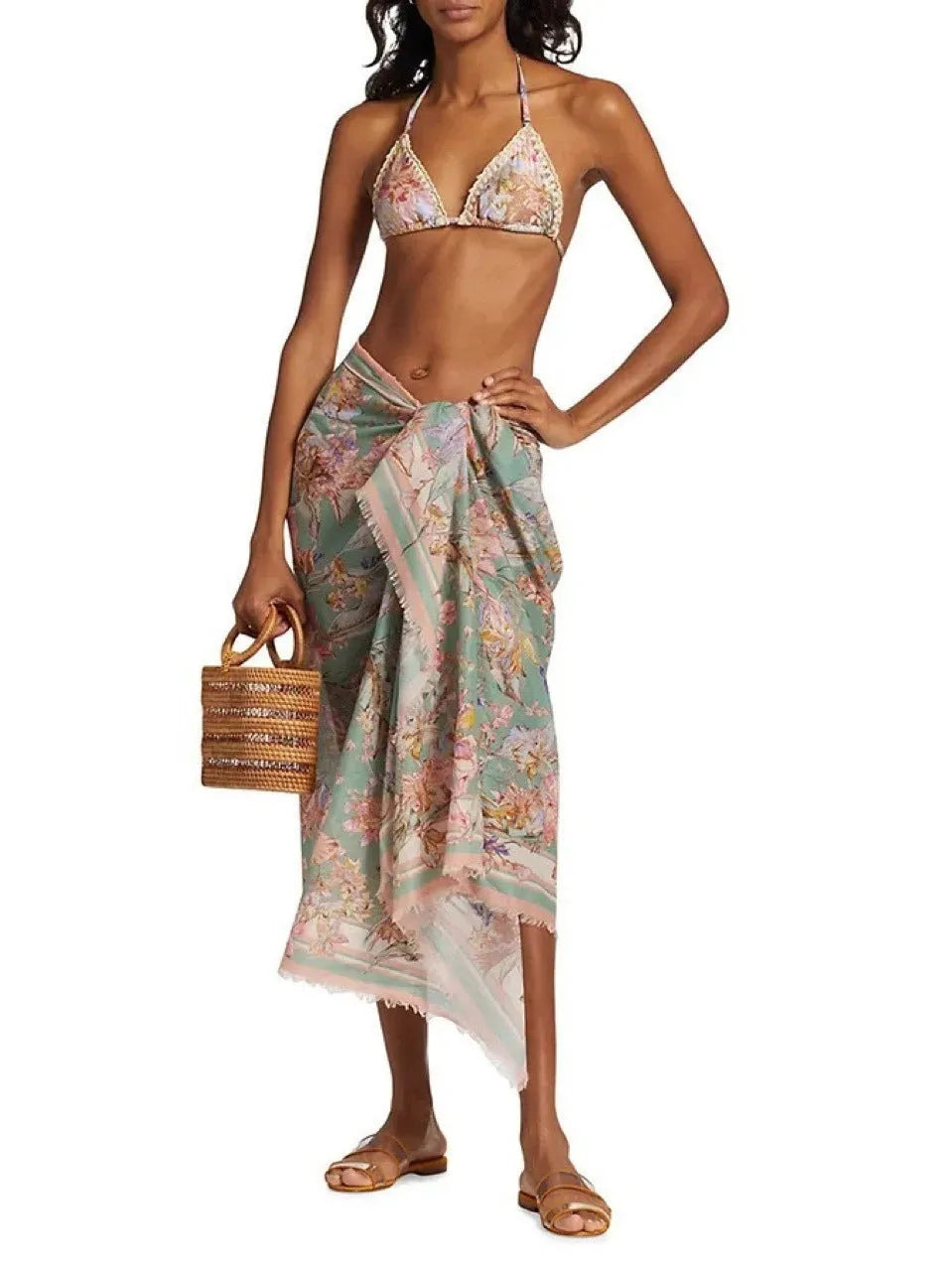 Creamy-white women's floral print bikini set with matching skirt on a hanger.