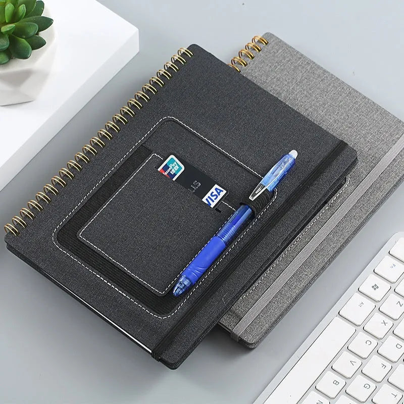 Erasable coil notebook with customisable cover options on waterproof rock stone paper, shown with pen.