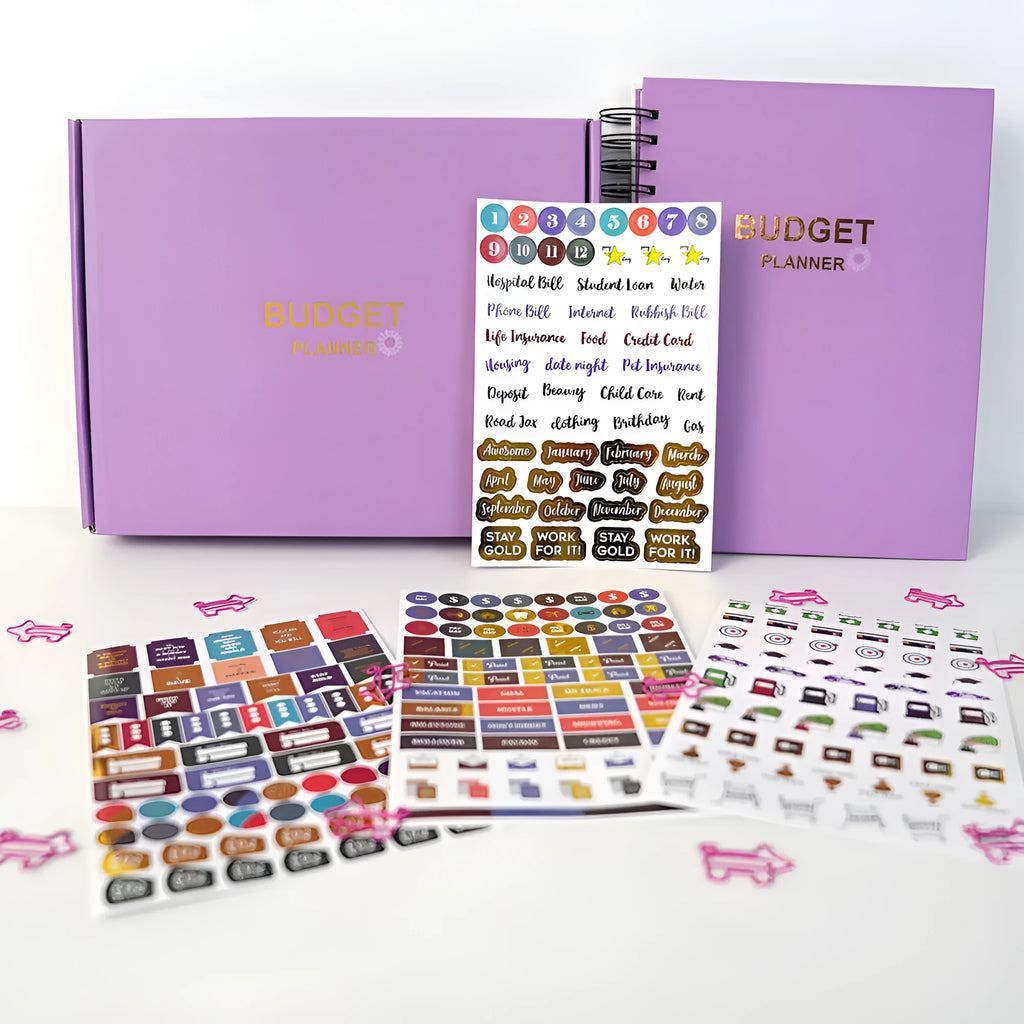 Purple coil-bound budget notebook with financial planning stickers and paper clips for monthly money management