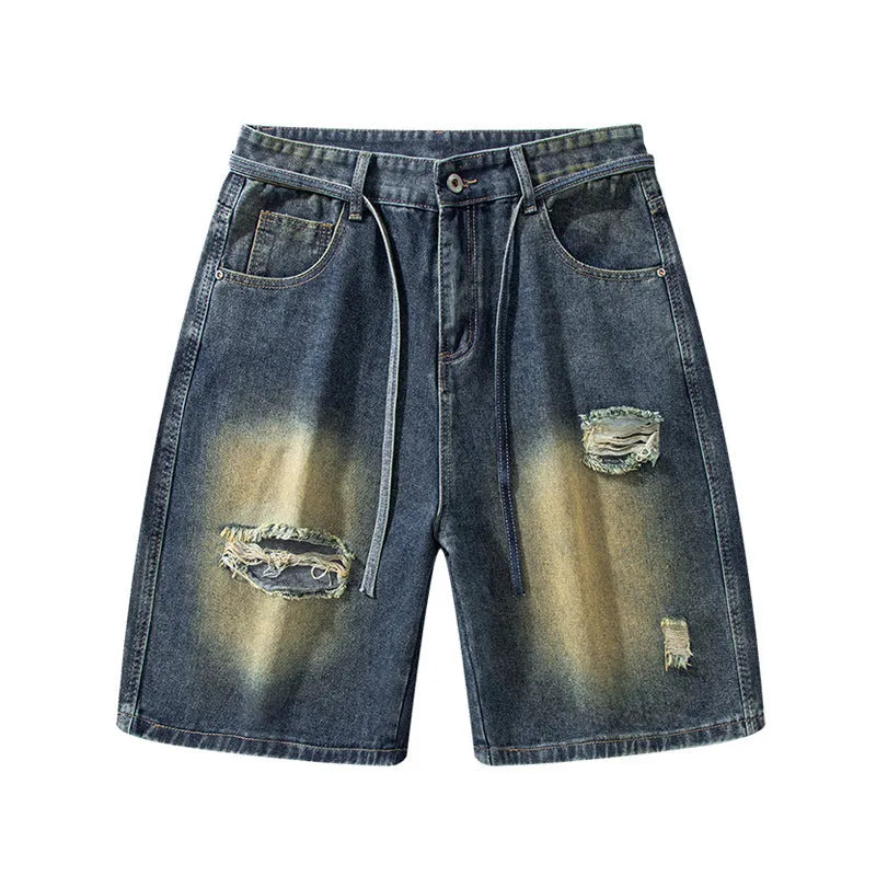 Man wearing retro blue loose fit ripped denim jeans with distressed details.