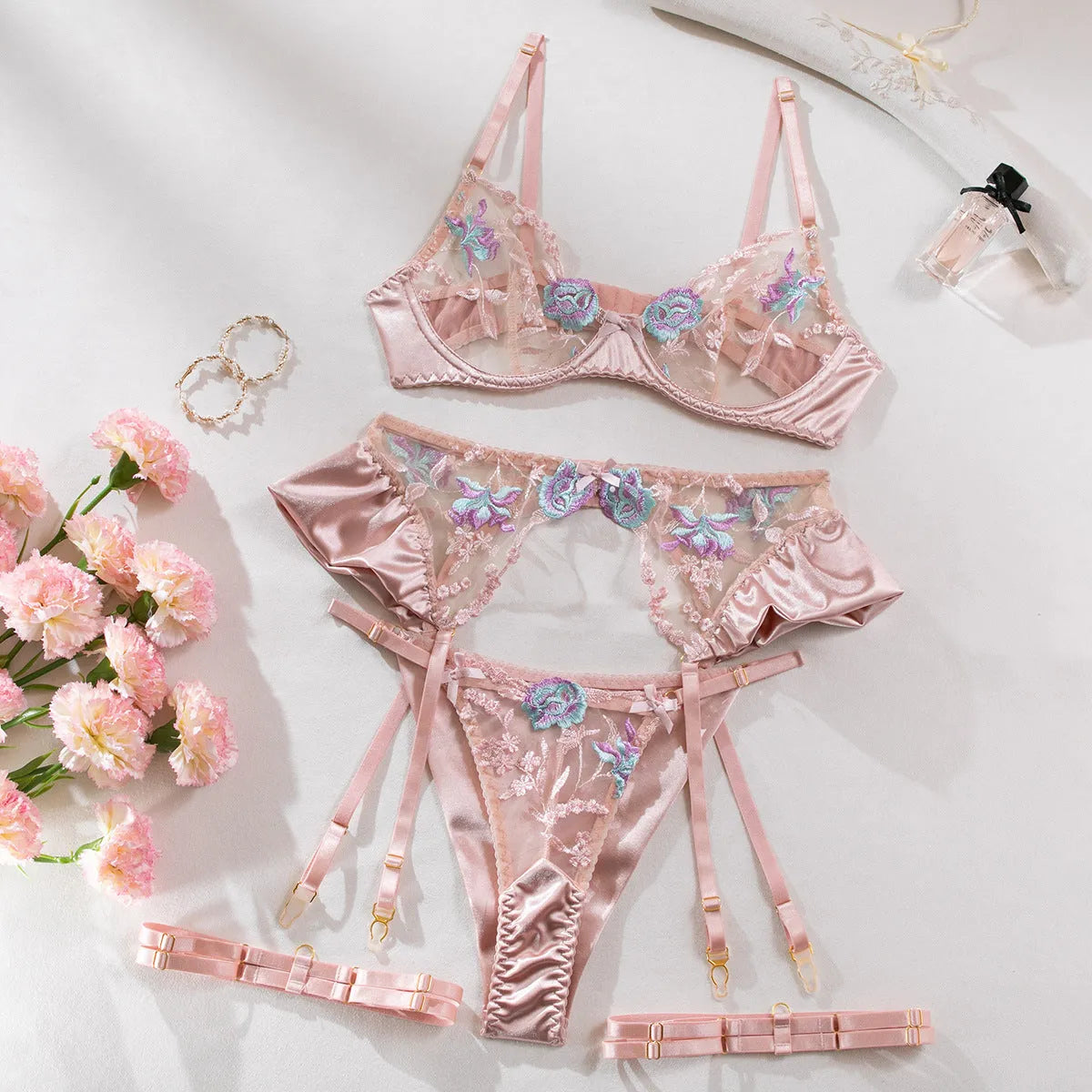Light purple satin four-piece lingerie set with embroidery detail on a hanger.