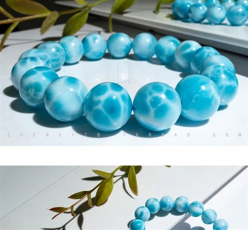 Blue Bodhi bead bracelet with a natural crystal sea-pattern stone charm on a wrist.