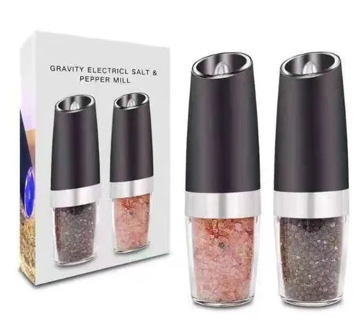 Electric gravity pepper grinder with clear acrylic body and blue LED light on a kitchen countertop