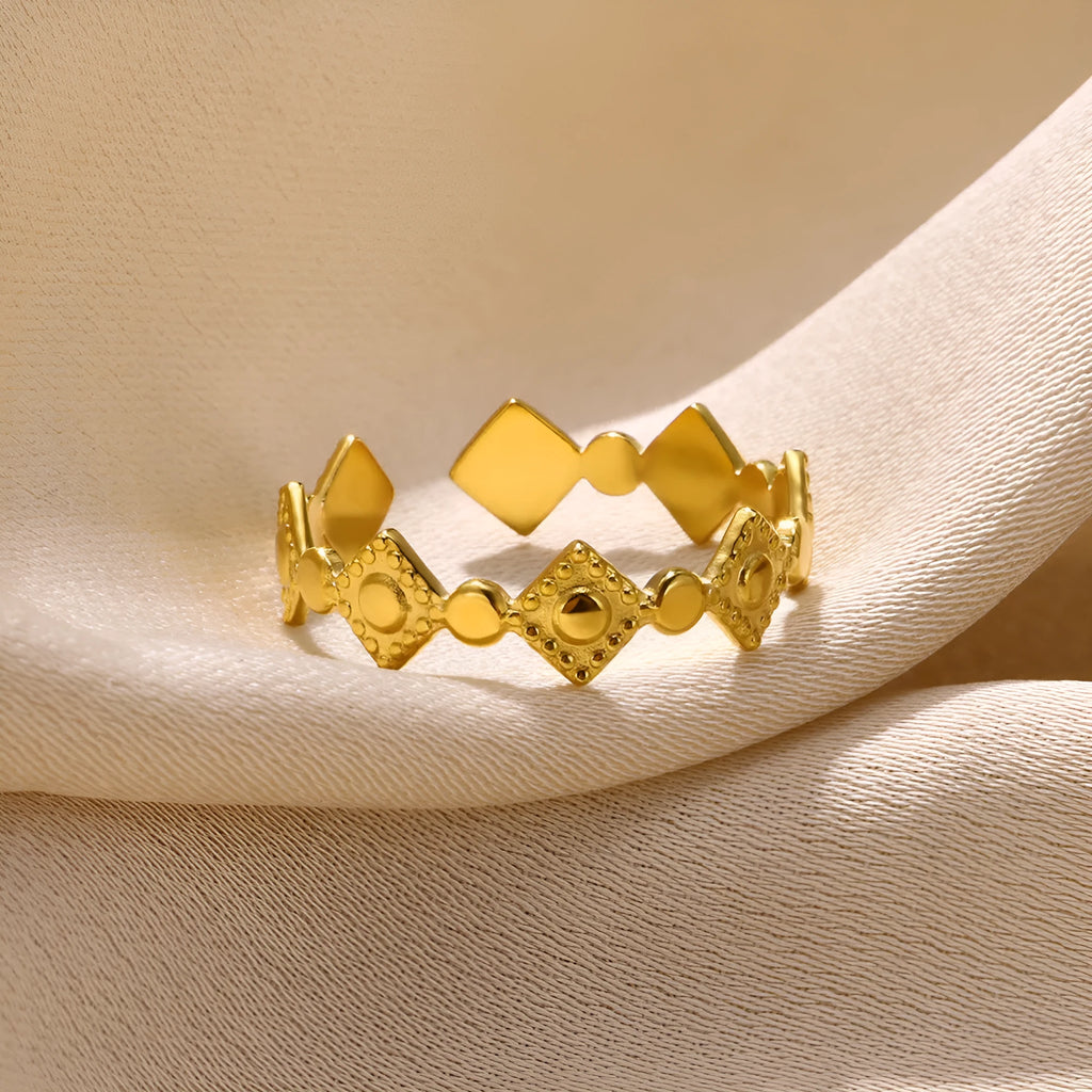 Gold coloured titanium steel women's ring with geometric shape and large diamond stone.