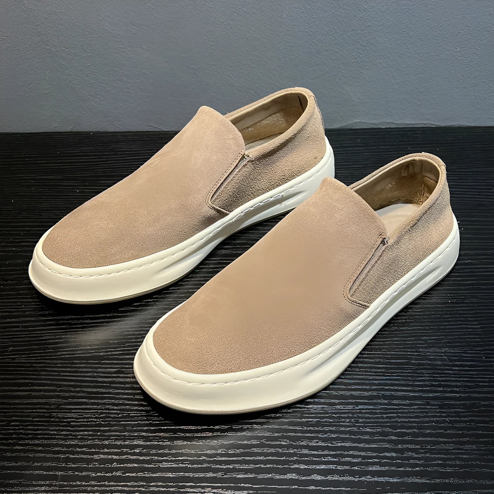 Men's grey slip-on casual shoes with round toe, mid-heel, and visible stitching on a rubber sole.