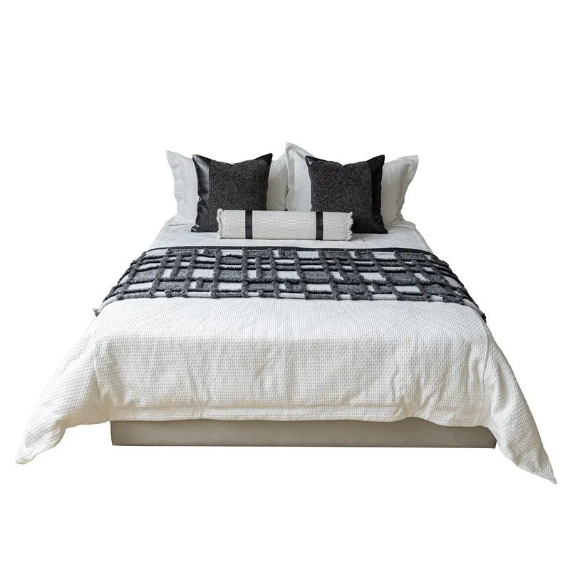 Grey and white plaid bed runner blanket with leather round pillow on 1.5m bed