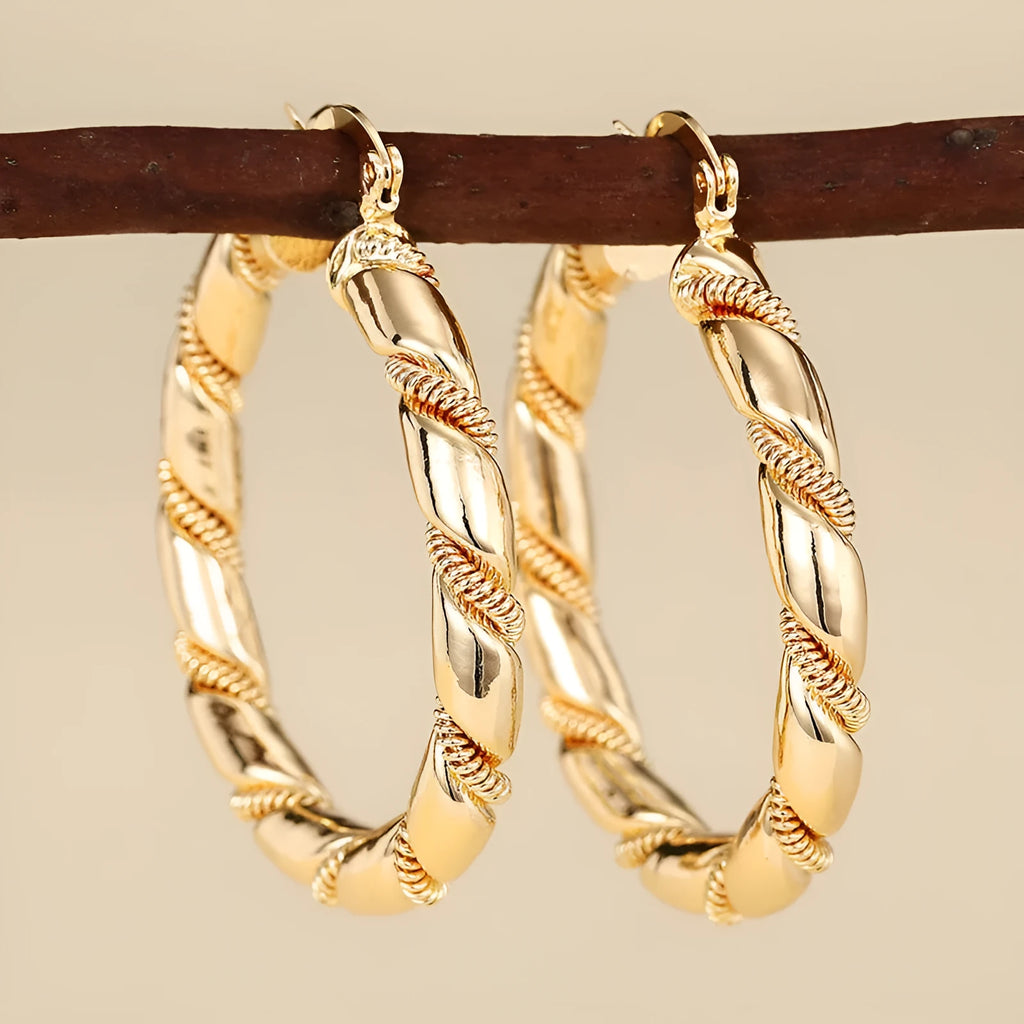 Geometric golden copper earrings with ear clip fastening showing ring and line design elements