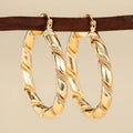 Geometric golden copper earrings with ear clip fastening showing ring and line design elements
