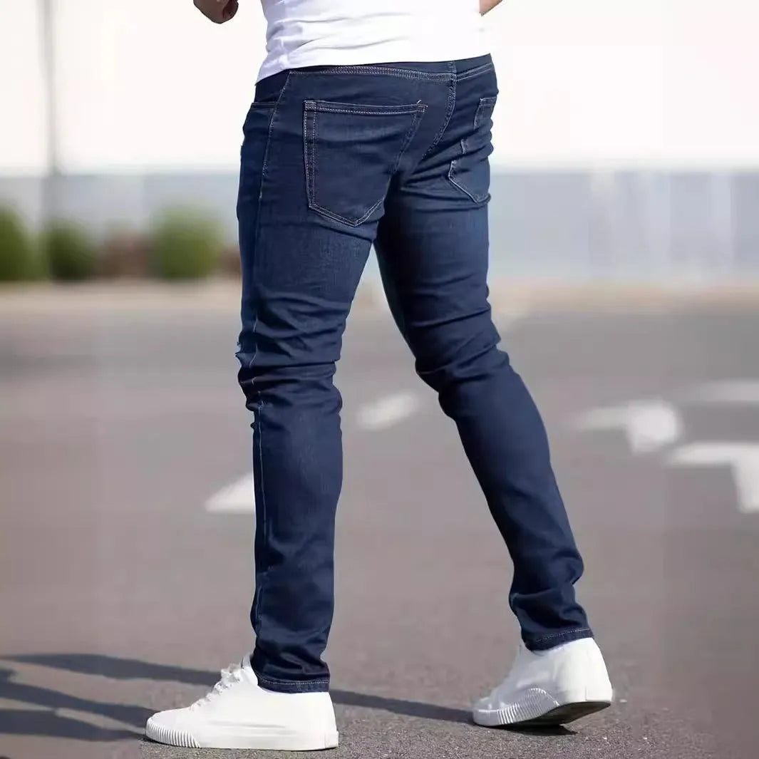 Man wearing dark blue slim-fit stretch cotton jeans with a skinny leg style.
