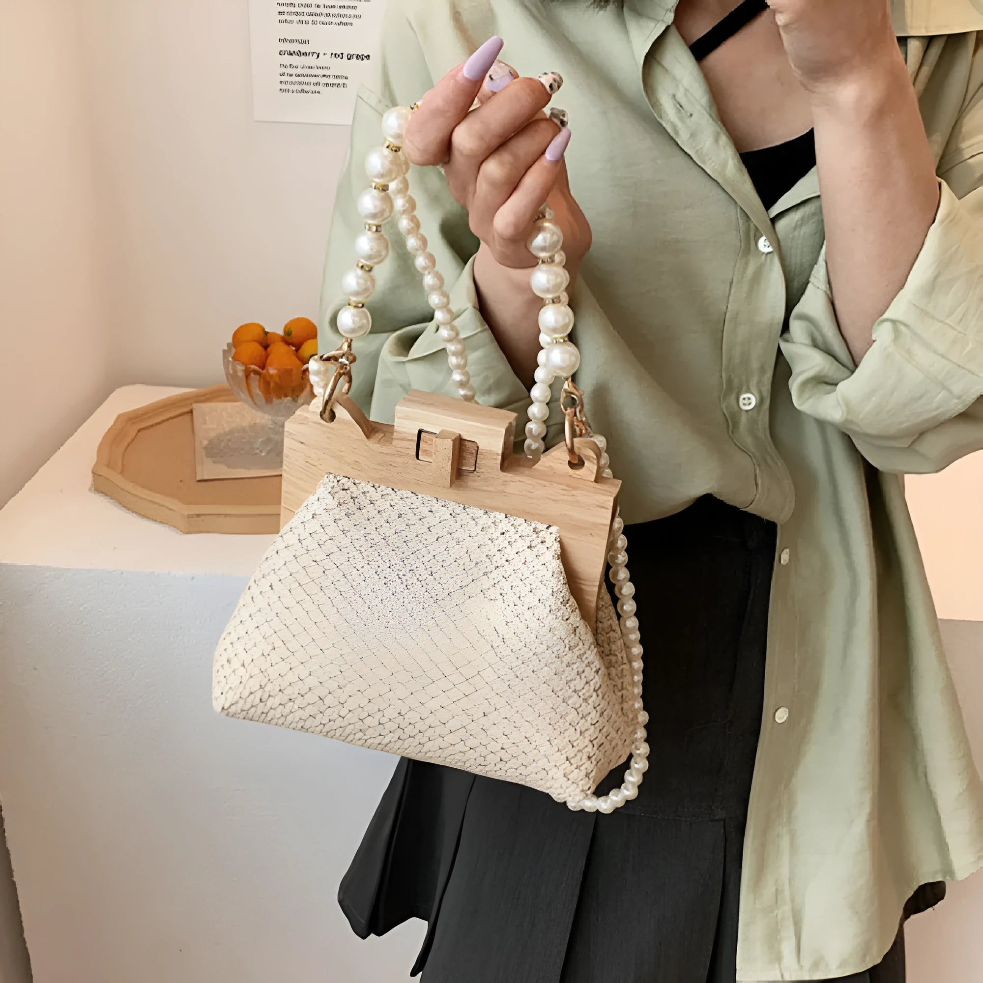 Women's straw woven shoulder bag with pearl chain detail showing interior organisation compartments