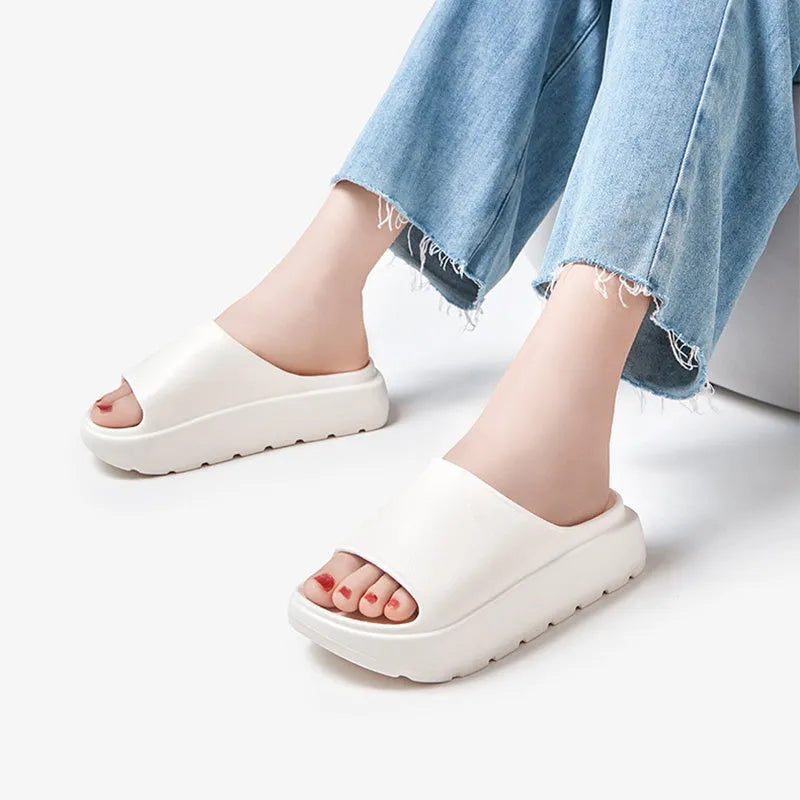 Women's beige fish mouth slippers with a thick 5.5cm EVA platform sole on a wooden floor.