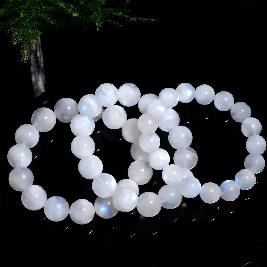 Natural blue moonlight round bead moonstone bracelet on a wrist, showing polished geometric beads.