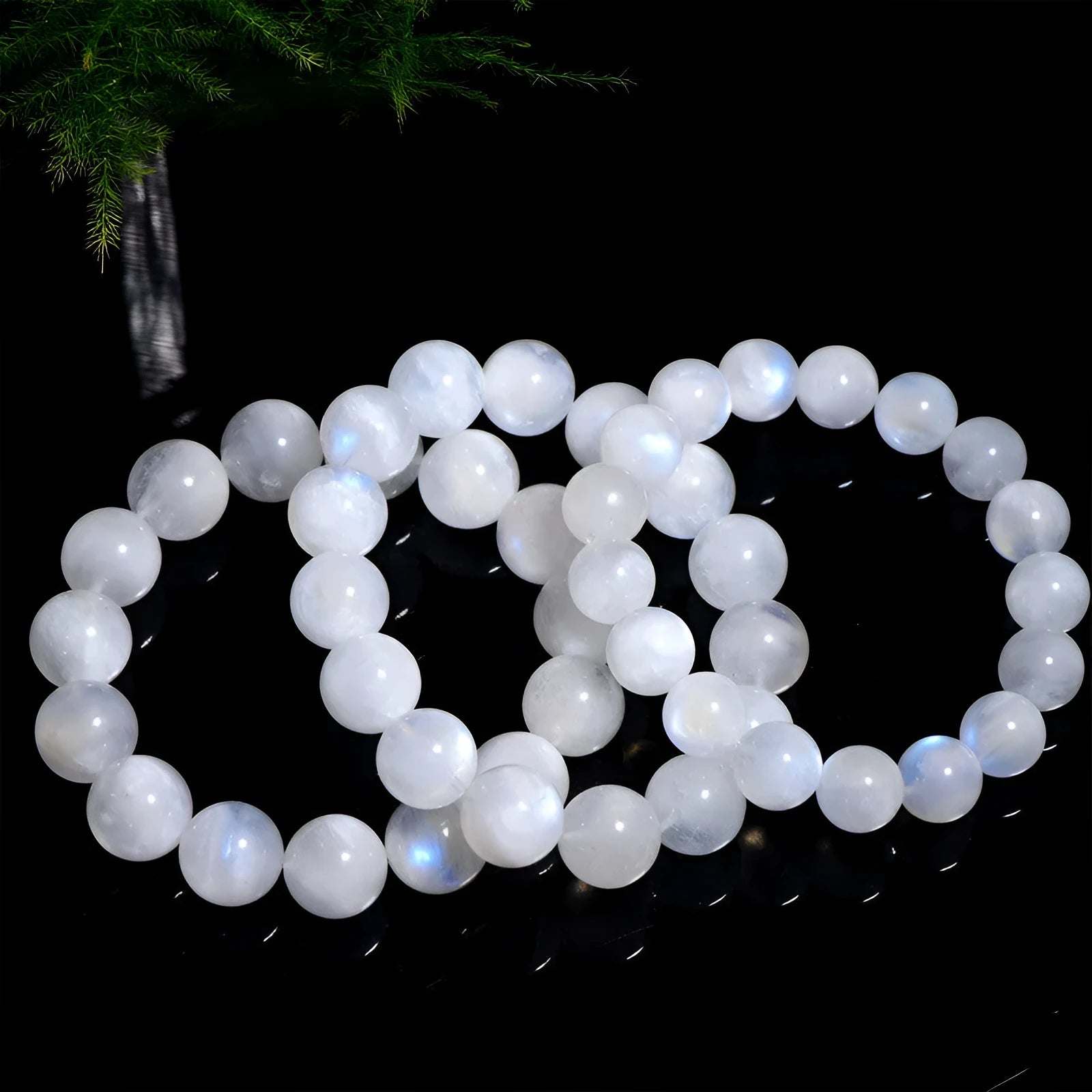 Natural blue moonlight round bead moonstone bracelet on a wrist, showing polished geometric beads.