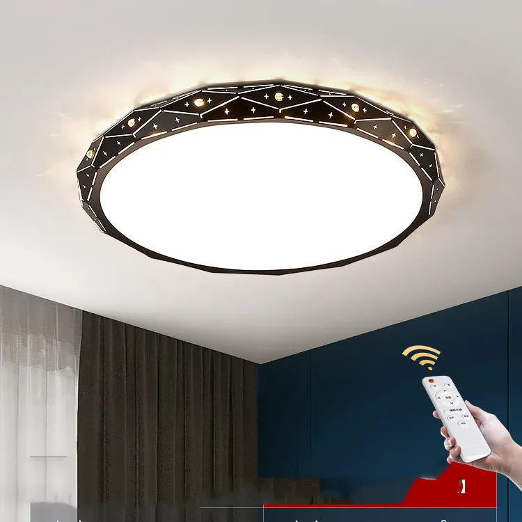 Round flush mount LED ceiling light with black iron frame on a white ceiling.