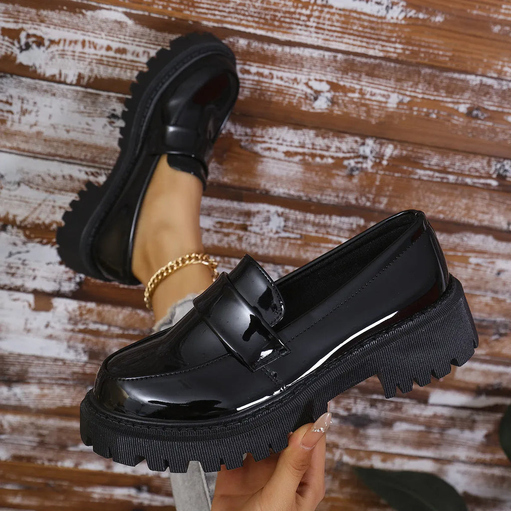 Plus size black slip-on loafers with chunky platform heel on a solid colour background