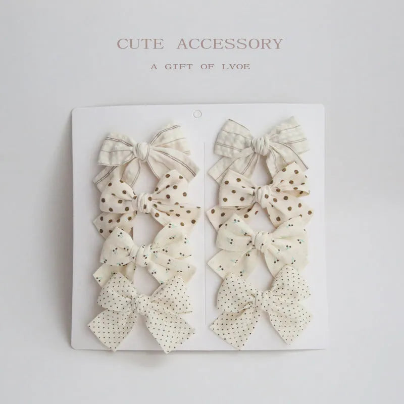 Set of children's fabric hairclips with dovetail bows in eight different colours and patterns.