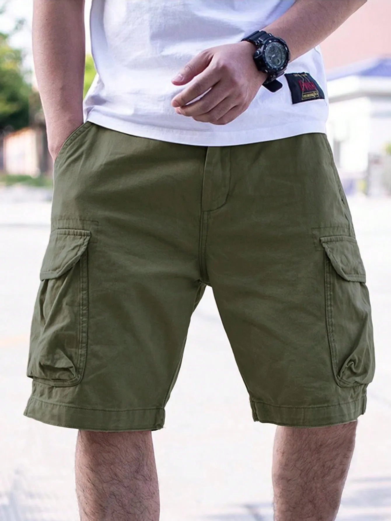 Man wearing loose-fitting army green cotton-blend retro workwear shorts for summer.