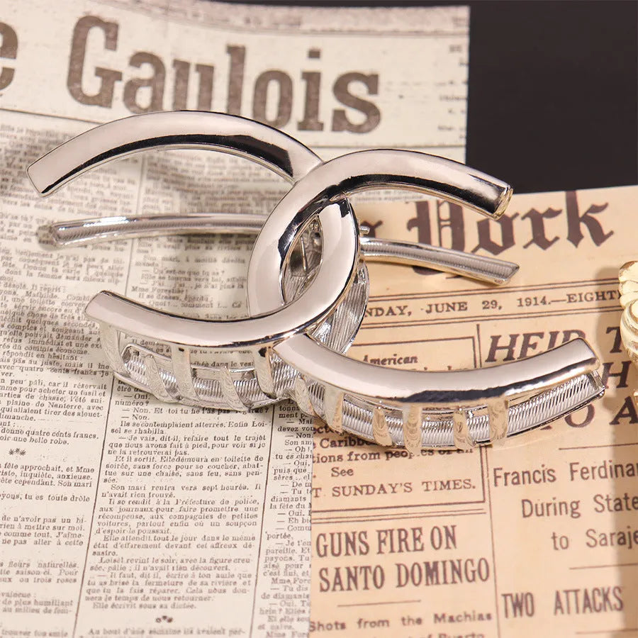Electroplated silver metal hair barrettes in various designs including cross, wave, and bow shapes.