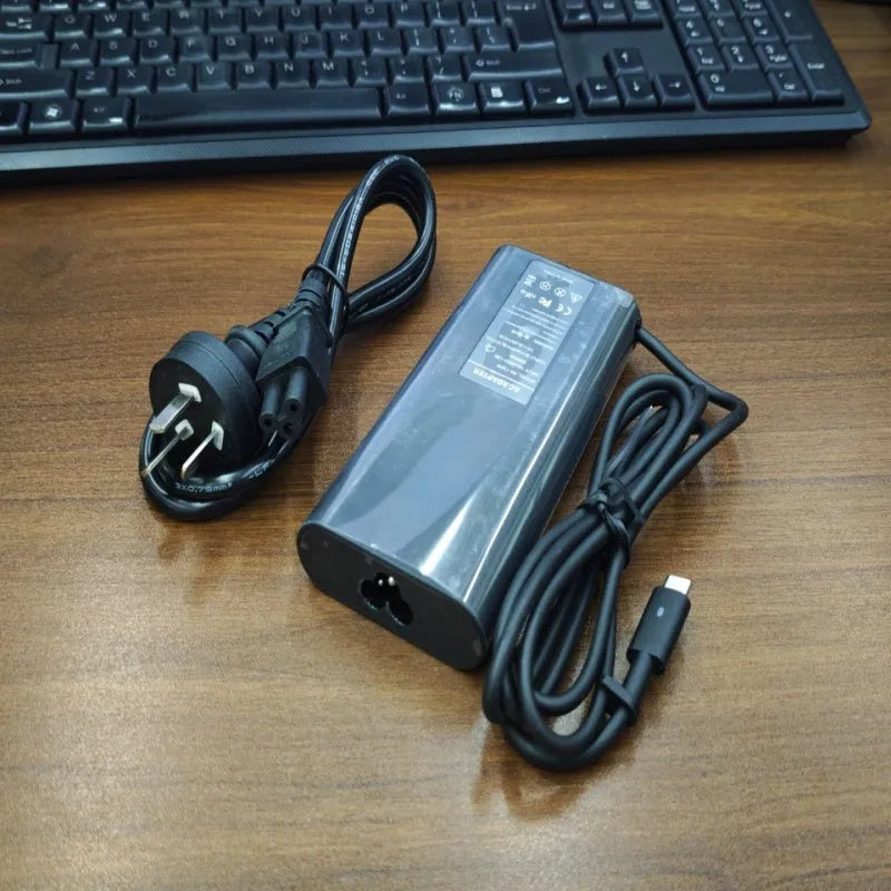 Black 65W Type-C laptop power adapter with six international power cords for worldwide charging