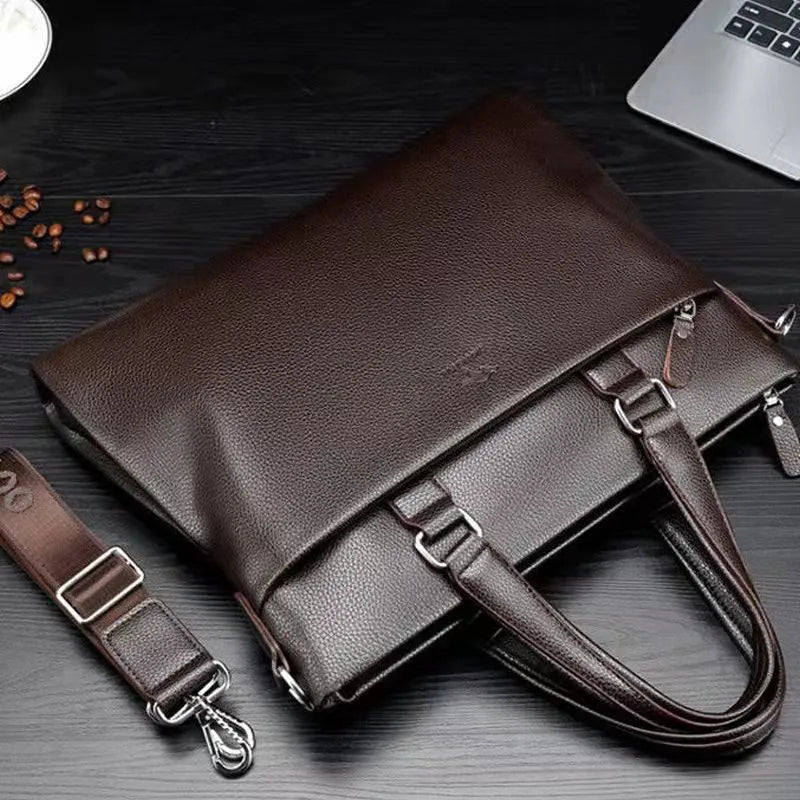 Black PU leather men's shoulder messenger bag with splicing style, shown next to a laptop