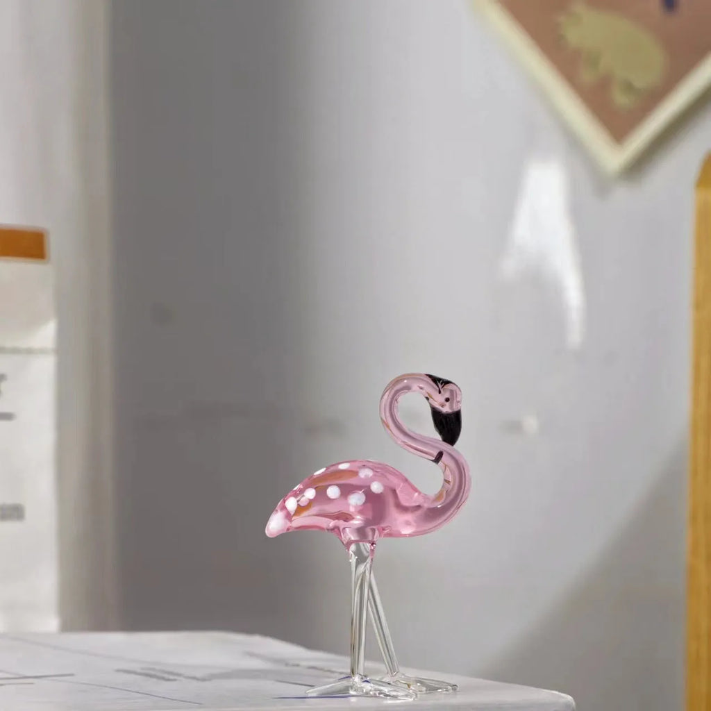 White crystal flamingo decorative ornaments with pink dots on a table