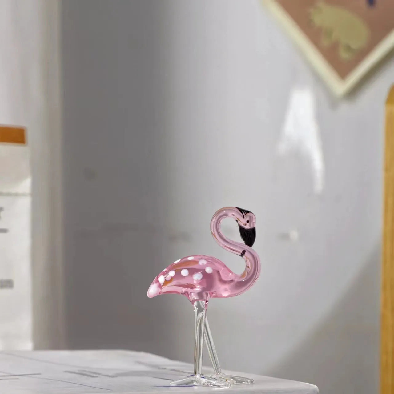 White crystal flamingo decorative ornaments with pink dots on a table