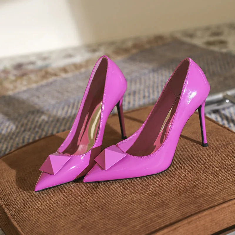 Women's pink patent leather stiletto heels with pointed toe, buckle ankle strap, and stiletto heel