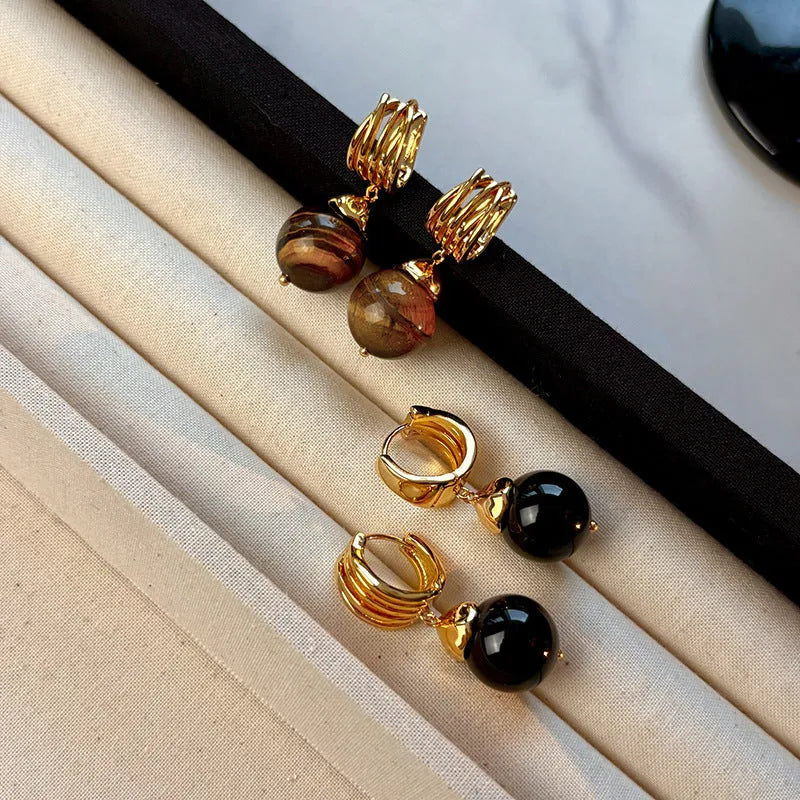 A pair of Fashion Maillard Tigereye earrings with a geometric shape and real gold plating, shown in brown and black colour options.