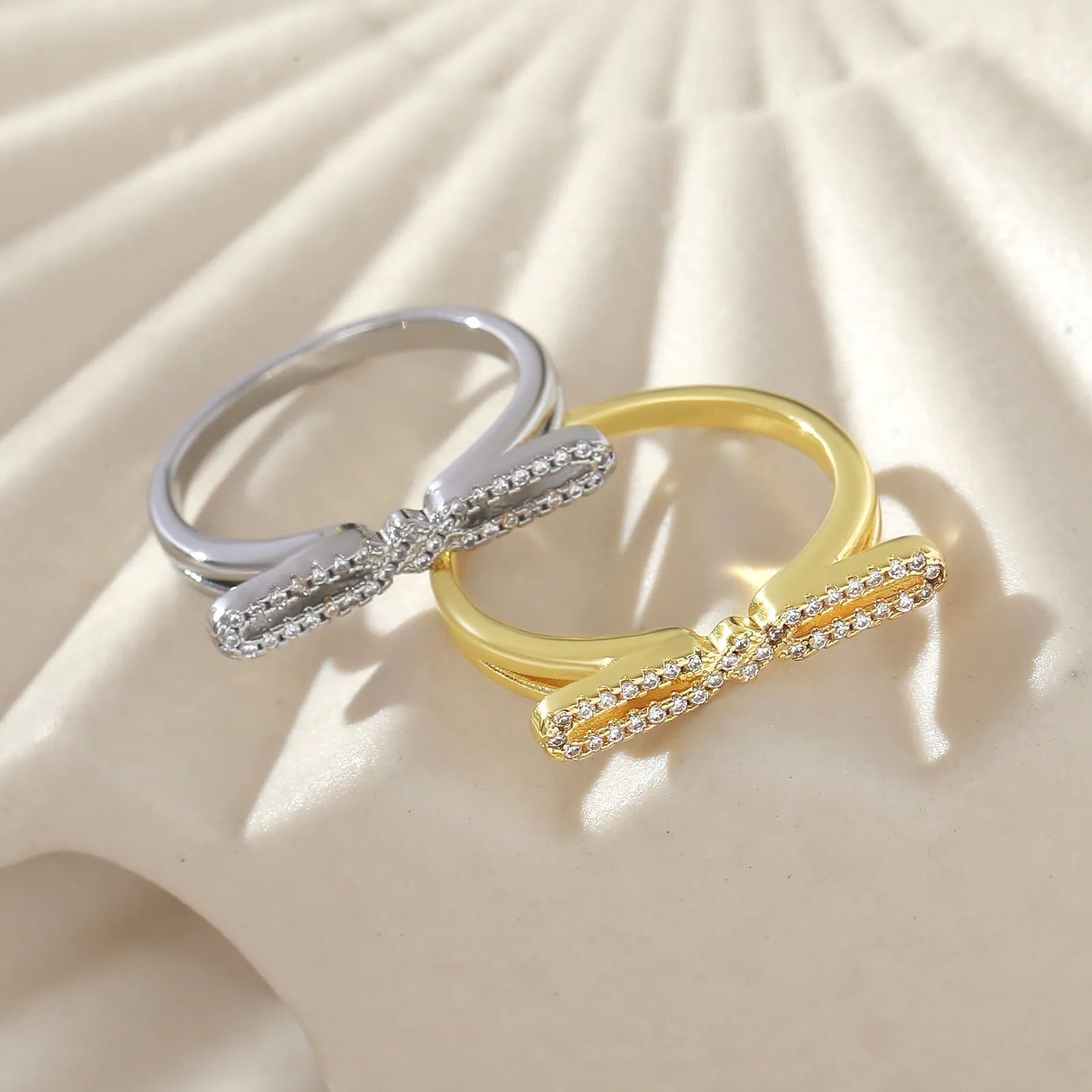 Fashion bowknot ring for women, copper with electroplated gold finish, bow shape on white background