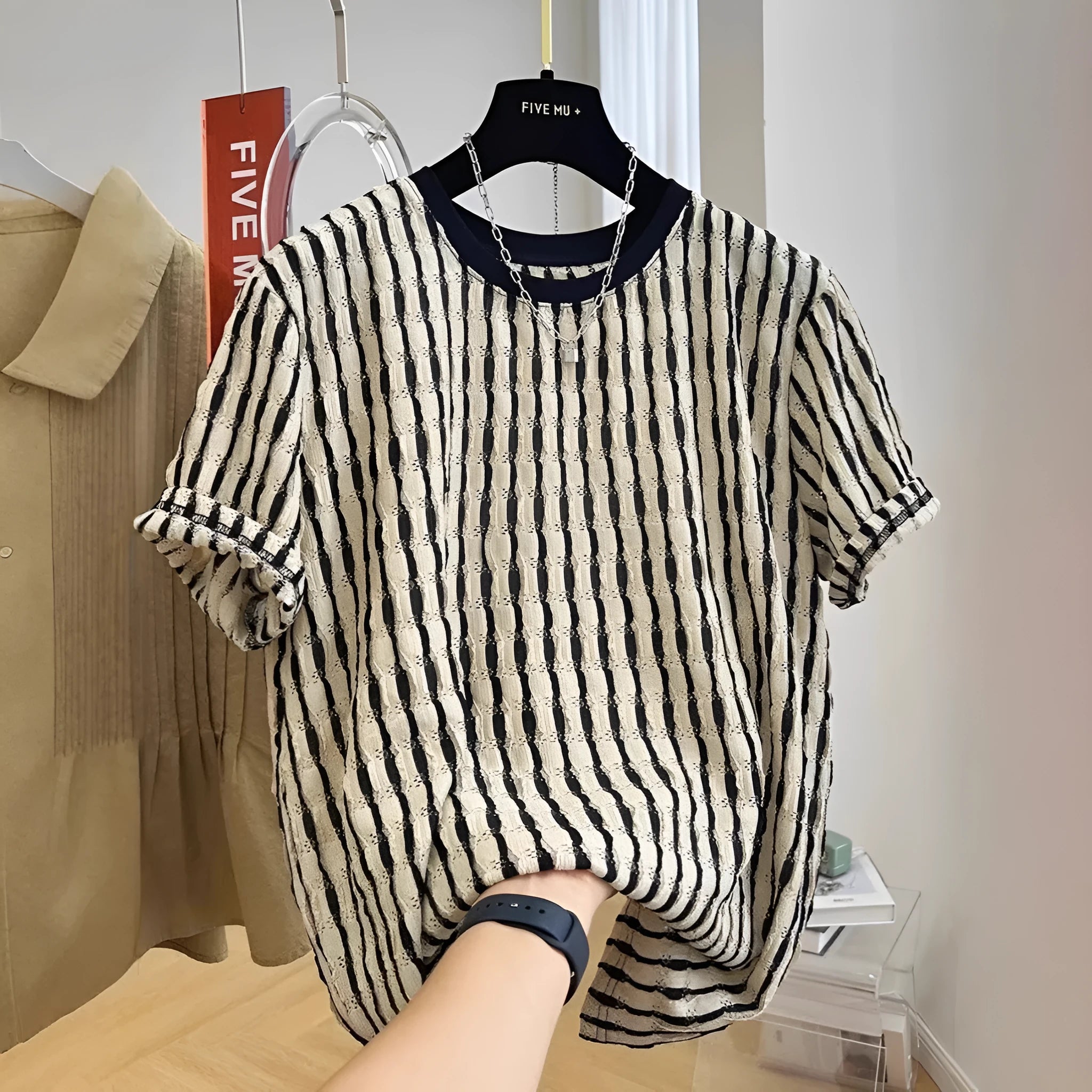 Black and white striped men's short sleeve loose fit pullover shirt on a hanger.