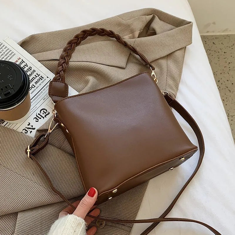 Unisex khaki PU leather crossbody bucket bag with woven texture and one shoulder strap.