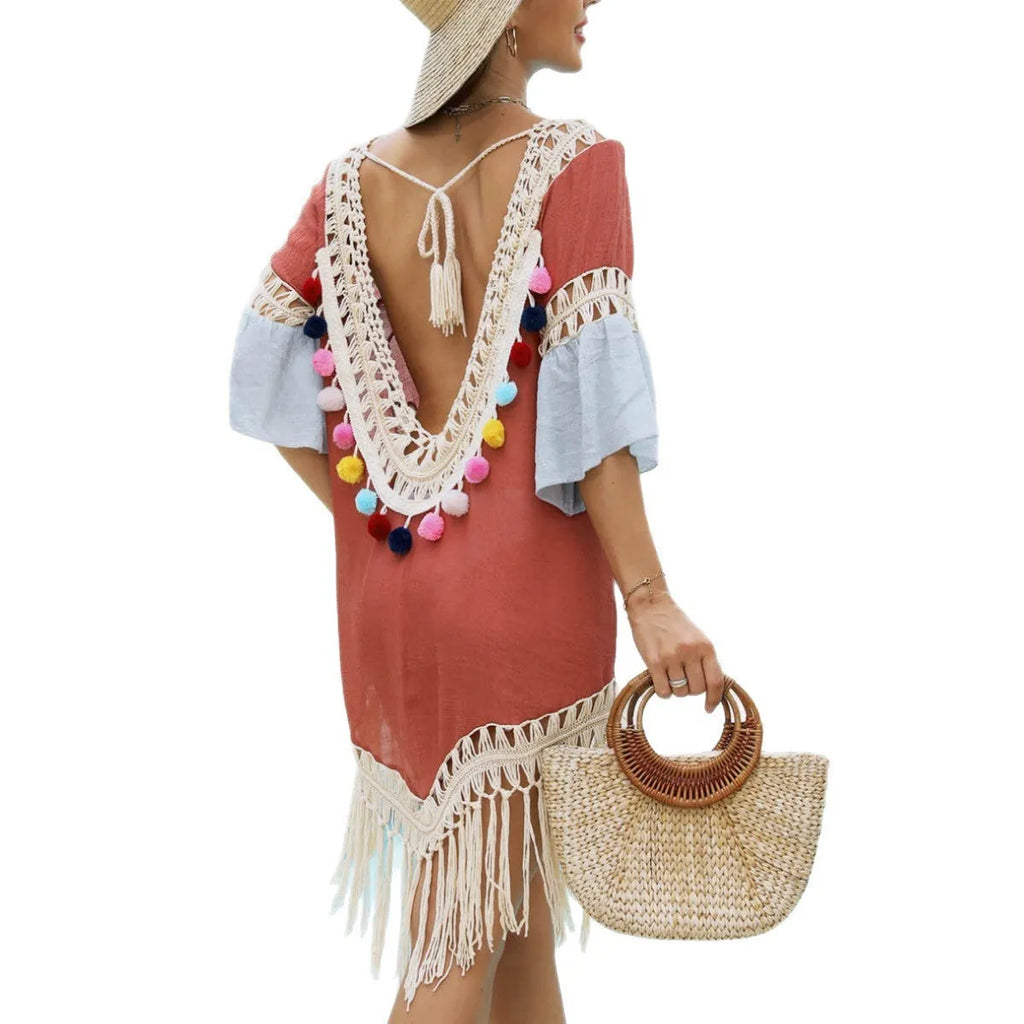 Orange floral pattern beach overskirt with hand crochet stitching and tassel details on a mannequin.