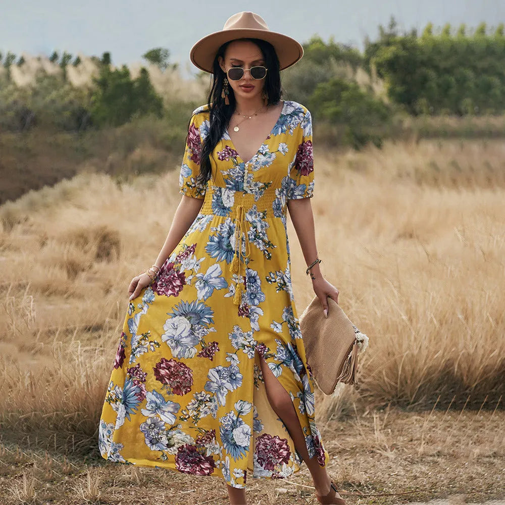 Yellow floral print women's dress with V-neck, short sleeves, elastic high waist, and a full mid-length skirt.
