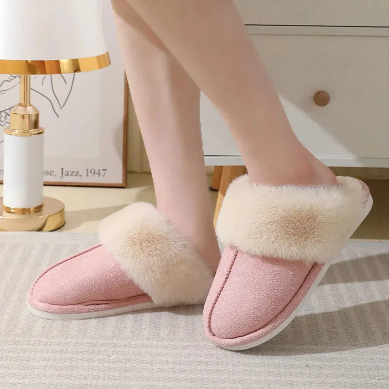 Brown plush indoor slippers with round toe, decorative stitching, and a light-coloured anti-slip sole.
