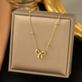 Gold bow necklace with adjustable cross chain on women's neck