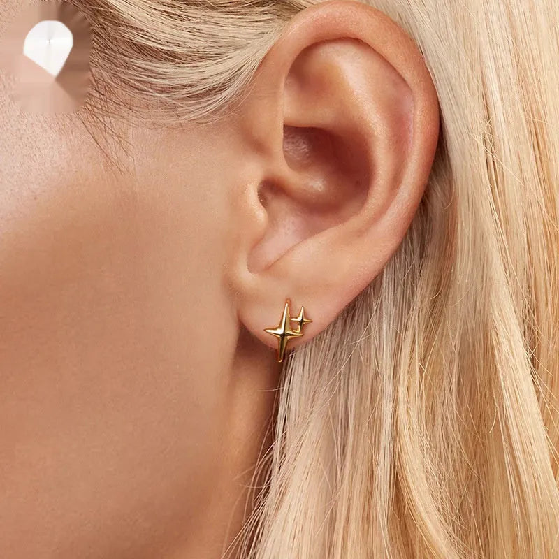 Minimalist sterling silver star-shaped clip-on earrings featuring a XINGX pattern and oxidised finish.