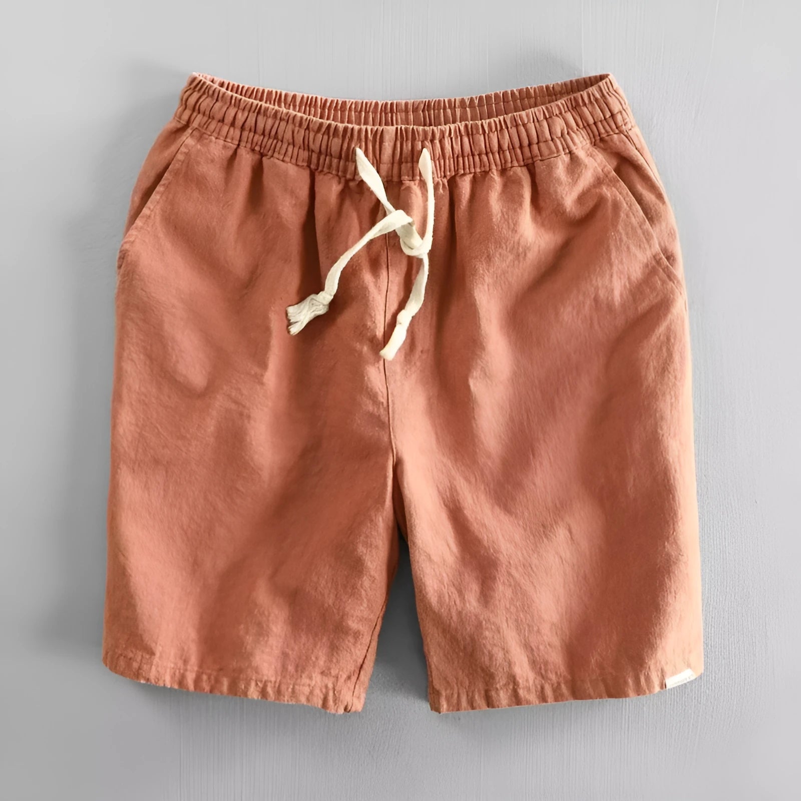 Man wearing loose-fit beige cotton linen casual shorts on a beach