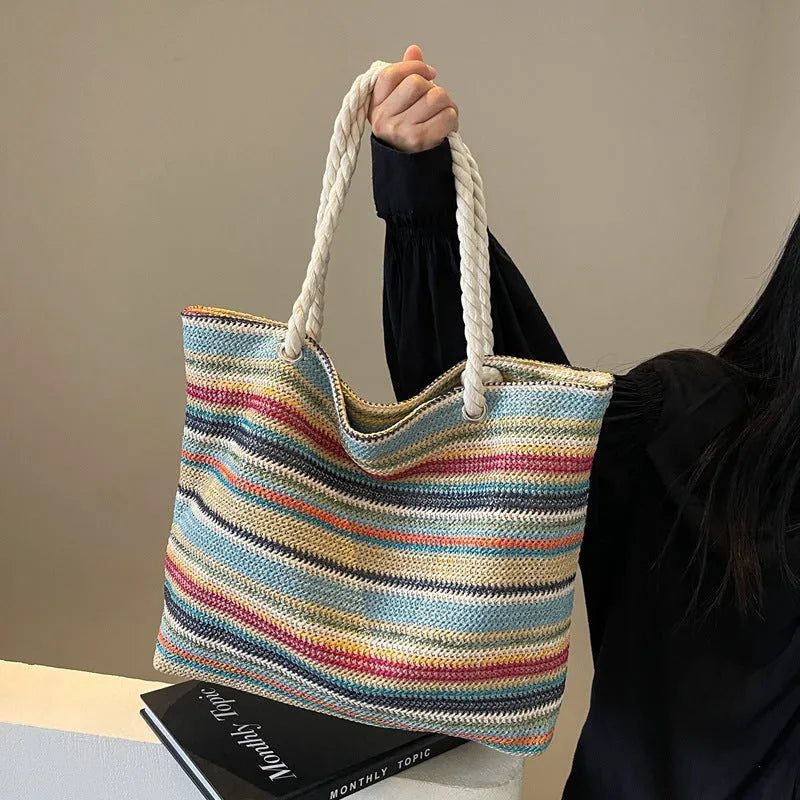 Blue woven straw and nylon shoulder bag with a single strap.