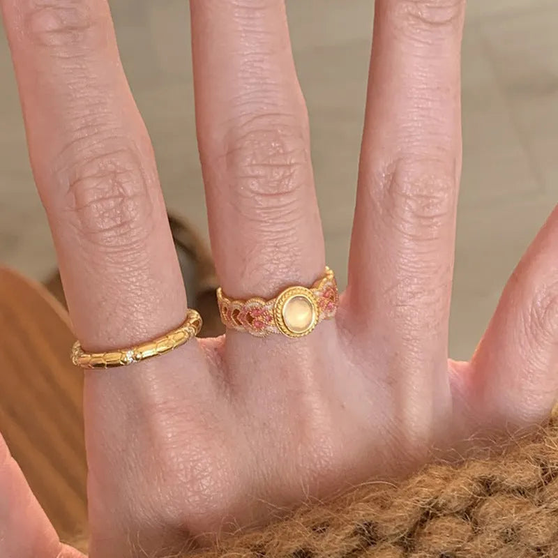 Openable geometric women's ring with pink crystal enamel on a gold plated copper band.