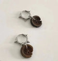 One pair of brown alloy ancient style burned gap button distressed earrings on neutral background